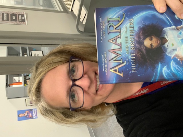 Mrs. Razor holding up Amari and the Night Brothers Book
